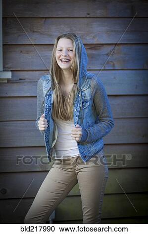 Stock Image - Smiling girl wearing denim jacket. Fotosearch