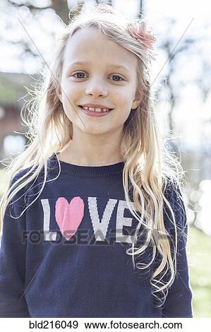 Stock Photo - Smiling girl wearing love sweater. Fotosearch