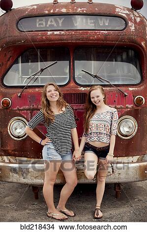 Smiling girls holding hands near dilapidated bus View Large Photo Image Picture - Smiling girls holding hands near dilapidated bus. Fotosearch