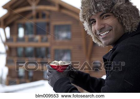 Smiling man drinking hot chocolate outdoors View Large Photo Image Stock Image - Smiling man drinking hot chocolate outdoors. Fotosearch