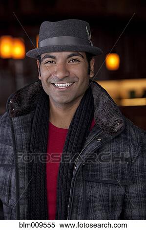 Stock Photography - Smiling man wearing scarf and fedora. Fotosearch