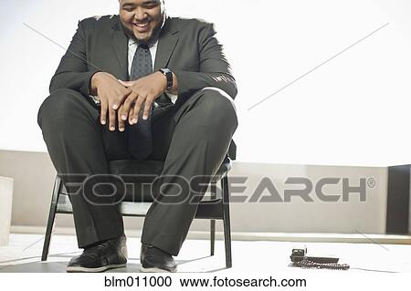 Smiling mixed race businessman sitting on patio View Large Photo Image Stock Image - Smiling mixed race businessman sitting on patio. Fotosearch