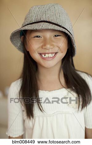 Stock Photo - Smiling mixed race girl wearing hat. Fotosearch