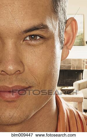 Smiling mixed race man in living room View Large Photo Image Stock Photo - Smiling mixed race man in living room. Fotosearch