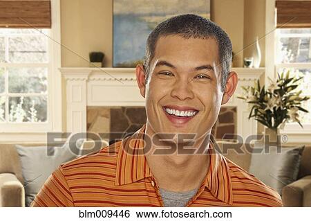 Smiling mixed race man in living room View Large Photo Image Stock Photograph - Smiling mixed race man in living room. Fotosearch