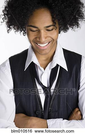 Stock Photograph - Smiling mixed race man with arms crossed. Fotosearch