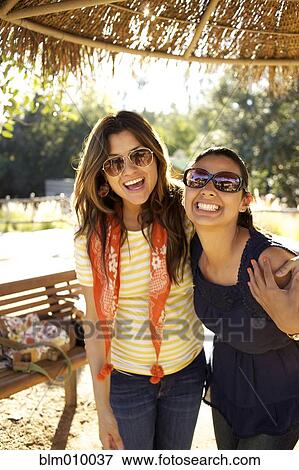 Smiling mixed race sisters hugging View Large Photo Image Stock Photo - Smiling mixed race sisters hugging. Fotosearch