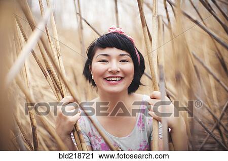 Smiling mixed race woman holding stalks in field View Large Photo Image Stock Image - Smiling mixed race woman holding stalks in field. Fotosearch
