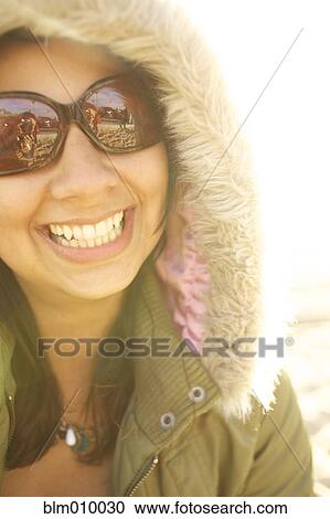 Stock Image - Smiling mixed race woman in fur hood. Fotosearch