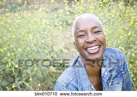 Stock Image - Smiling mixed race woman outdoors. Fotosearch