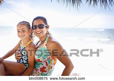 Stock Photography - Smiling mother and daughter enjoying tropical beach. Fotosearch