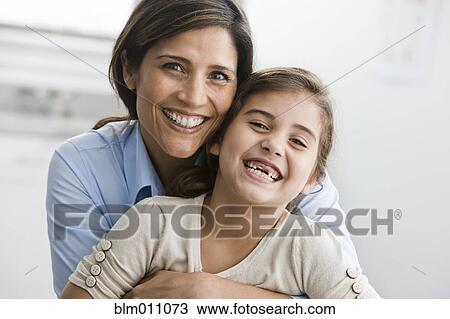 Smiling mother and daughter hugging View Large Photo Image Stock Image - Smiling mother and daughter hugging. Fotosearch