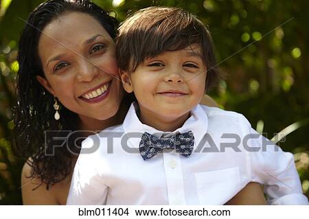 Picture - Smiling mother holding son on her lap. Fotosearch