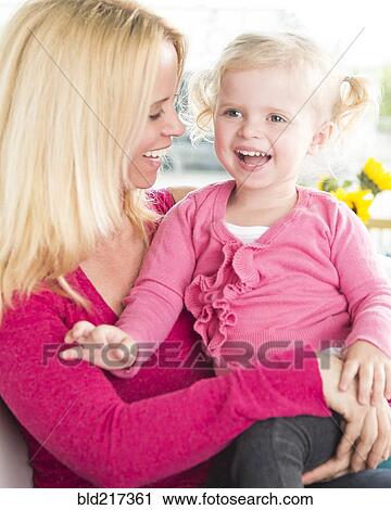 Smiling mother hugging daughter View Large Photo Image Stock Image - Smiling mother hugging daughter. Fotosearch
