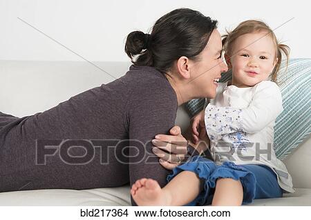 Picture - Smiling mother nuzzling daughter. Fotosearch