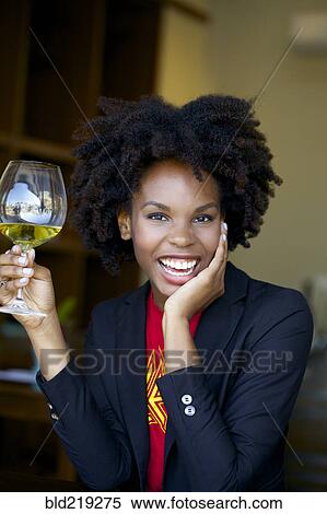 Stock Photography - Smiling woman drinking glass of white wine. Fotosearch