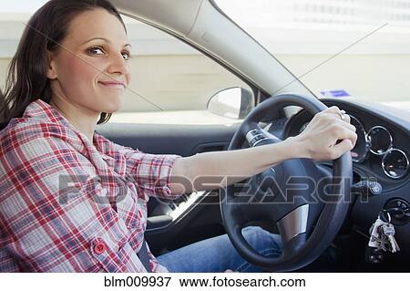 Smiling woman driving car View Large Photo Image Stock Photo - Smiling woman driving car. Fotosearch
