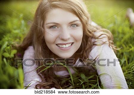 Smiling woman laying in rural field View Large Photo Image Picture - Smiling woman laying in rural field. Fotosearch