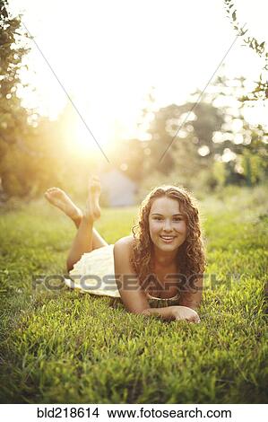 Smiling woman laying in rural field View Large Photo Image Picture - Smiling woman laying in rural field. Fotosearch