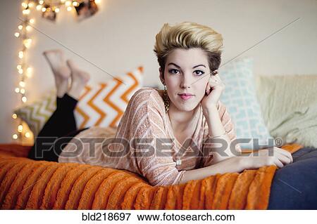 Smiling woman laying on bed View Large Photo Image Stock Photo - Smiling woman laying on bed. Fotosearch