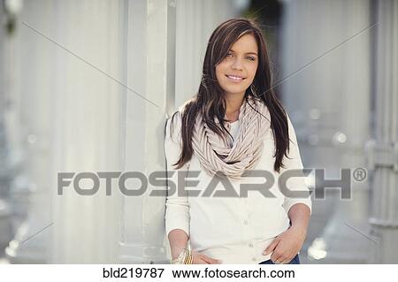 Stock Photo - Smiling woman leaning on columns. Fotosearch