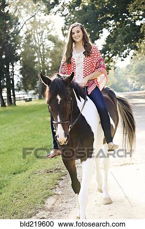 Smiling woman riding horse on path View Large Photo Image Stock Image - Smiling woman riding horse on path. Fotosearch