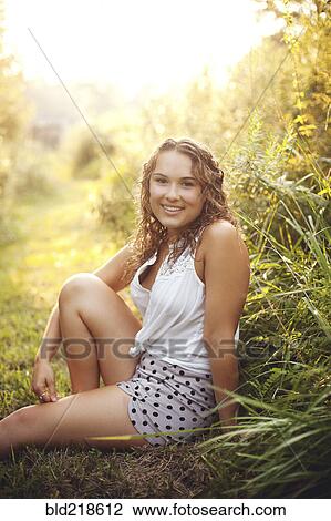 Smiling woman sitting in rural field View Large Photo Image Stock Image - Smiling woman sitting in rural field. Fotosearch