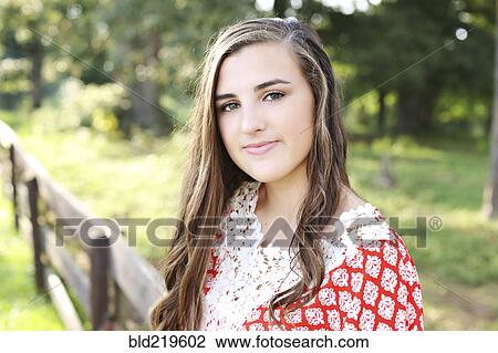 Smiling woman standing at wooden fence in rural field View Large Photo Image Stock Image - Smiling woman standing at wooden fence in rural field. Fotosearch