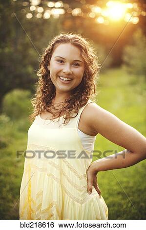 Smiling woman standing in rural field View Large Photo Image Stock Photograph - Smiling woman standing in rural field. Fotosearch