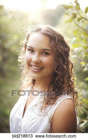 Stock Image - Smiling woman standing outdoors. Fotosearch