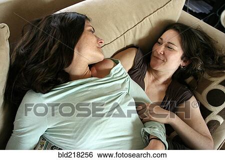 Smiling women relaxing on sofa View Large Photo Image Stock Photograph - Smiling women relaxing on sofa. Fotosearch