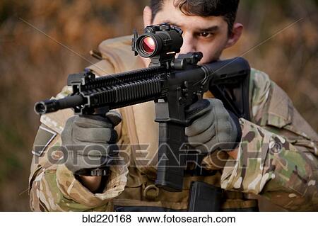 Stock Photo - Soldier aiming automatic weapon during training. Fotosearch