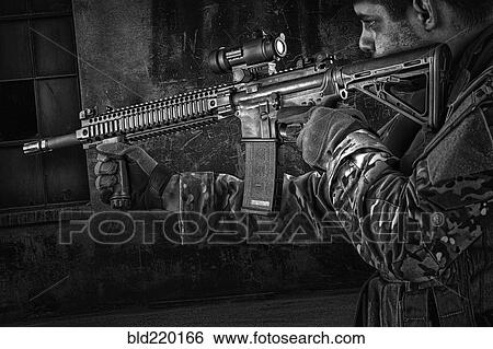 Stock Photograph - Soldier aiming automatic weapon during training. Fotosearch