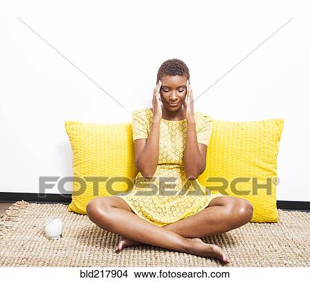 Picture - Stressed Black woman meditating on floor. Fotosearch