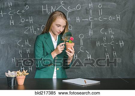 Stock Photography - Student examining plant in science class. Fotosearch
