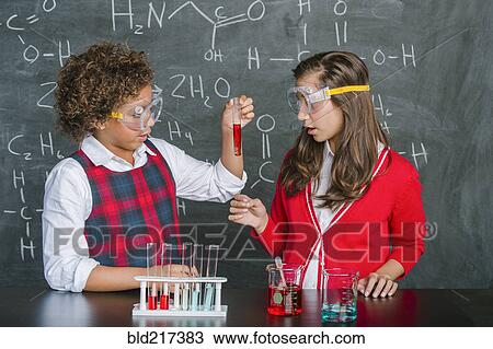 Stock Image - Students doing experiment in science class. Fotosearch