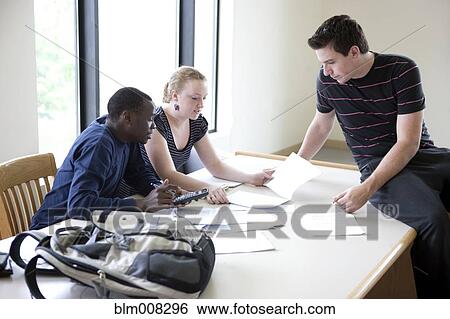 Stock Photograph - Students working together in library. Fotosearch