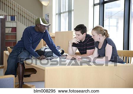 Stock Photography - Students working together in library. Fotosearch