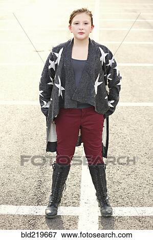 Stock Photo - Stylish Caucasian girl standing in parking lot. Fotosearch