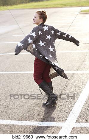 Stock Photo - Stylish Caucasian girl walking in parking lot. Fotosearch