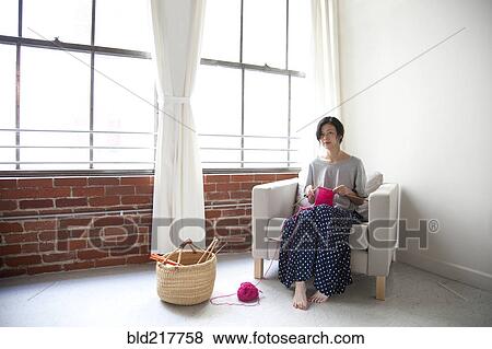 Taiwanese woman knitting in armchair near window View Large Photo Image Stock Photo - Taiwanese woman knitting in armchair near window. Fotosearch
