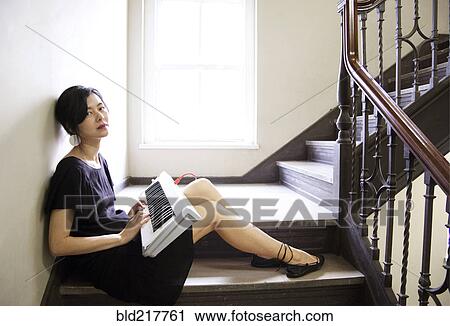 Stock Image - Taiwanese woman playing keyboard on staircase. Fotosearch