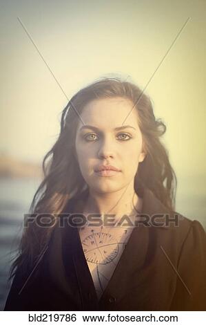 Stock Photograph - Tattooed woman standing on beach. Fotosearch