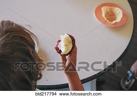 Teenage boy eating cupcake View Large Photo Image Picture - Teenage boy eating cupcake. Fotosearch