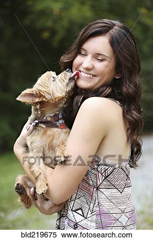 Teenage girl carrying puppy in rural field View Large Photo Image Stock Photography - Teenage girl carrying puppy in rural field. Fotosearch