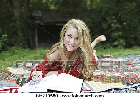 Teenage girl drawing in notebook on blanket View Large Photo Image Stock Image - Teenage girl drawing in notebook on blanket. Fotosearch