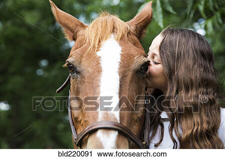 Teenage girl kissing face of horse View Large Photo Image Stock Image - Teenage girl kissing face of horse. Fotosearch