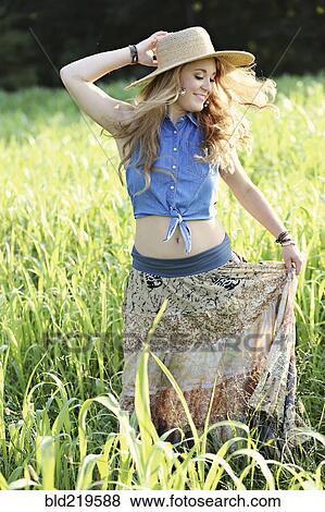 Stock Photo - Teenage girl playing in tall grass. Fotosearch