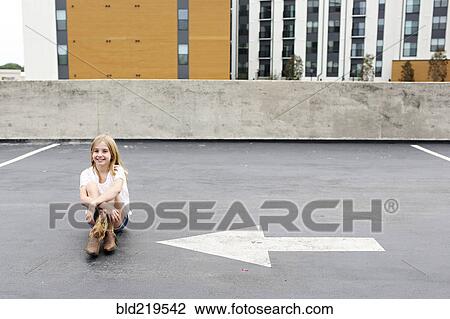 Teenage girl sitting on urban rooftop parking lot View Large Photo Image Stock Image - Teenage girl sitting on urban rooftop parking lot. Fotosearch