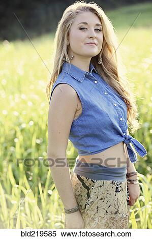 Stock Photography - Teenage girl standing in tall grass. Fotosearch